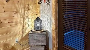 Un interior de madera con una puerta, un farol y herramientas en la pared.