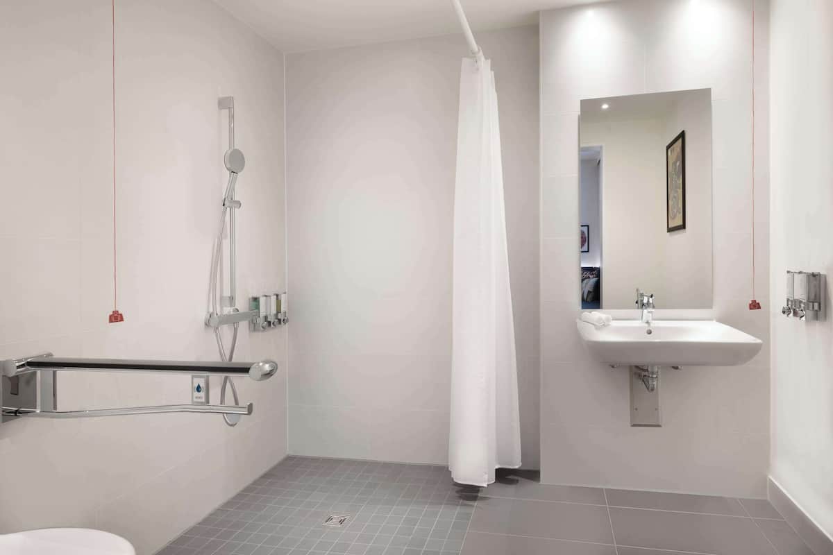 A modern bathroom with a walk-in shower, a toilet, and a sink.