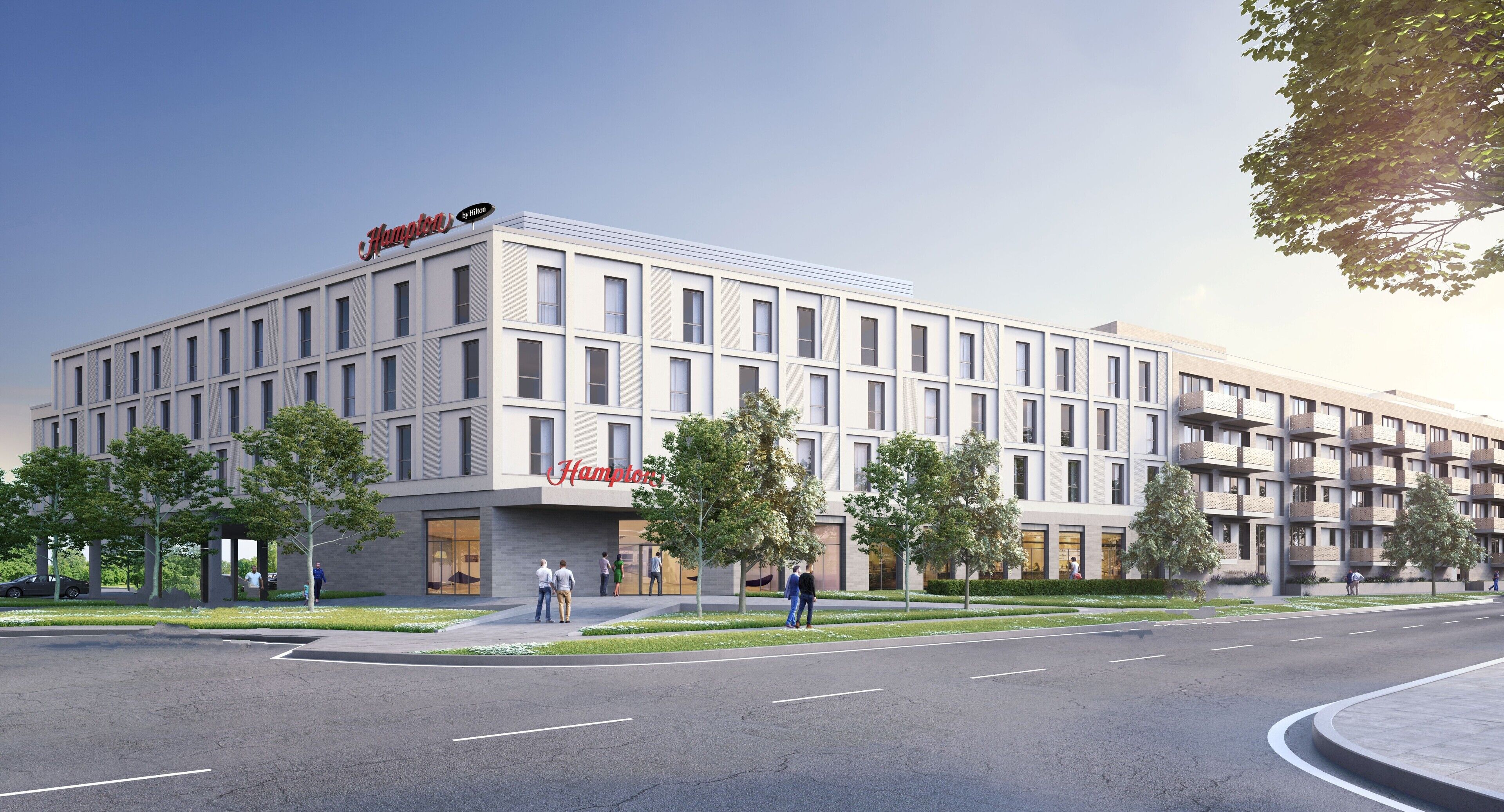 A modern hotel with a flat facade, multiple windows, and a prominent 'Hampton' sign.