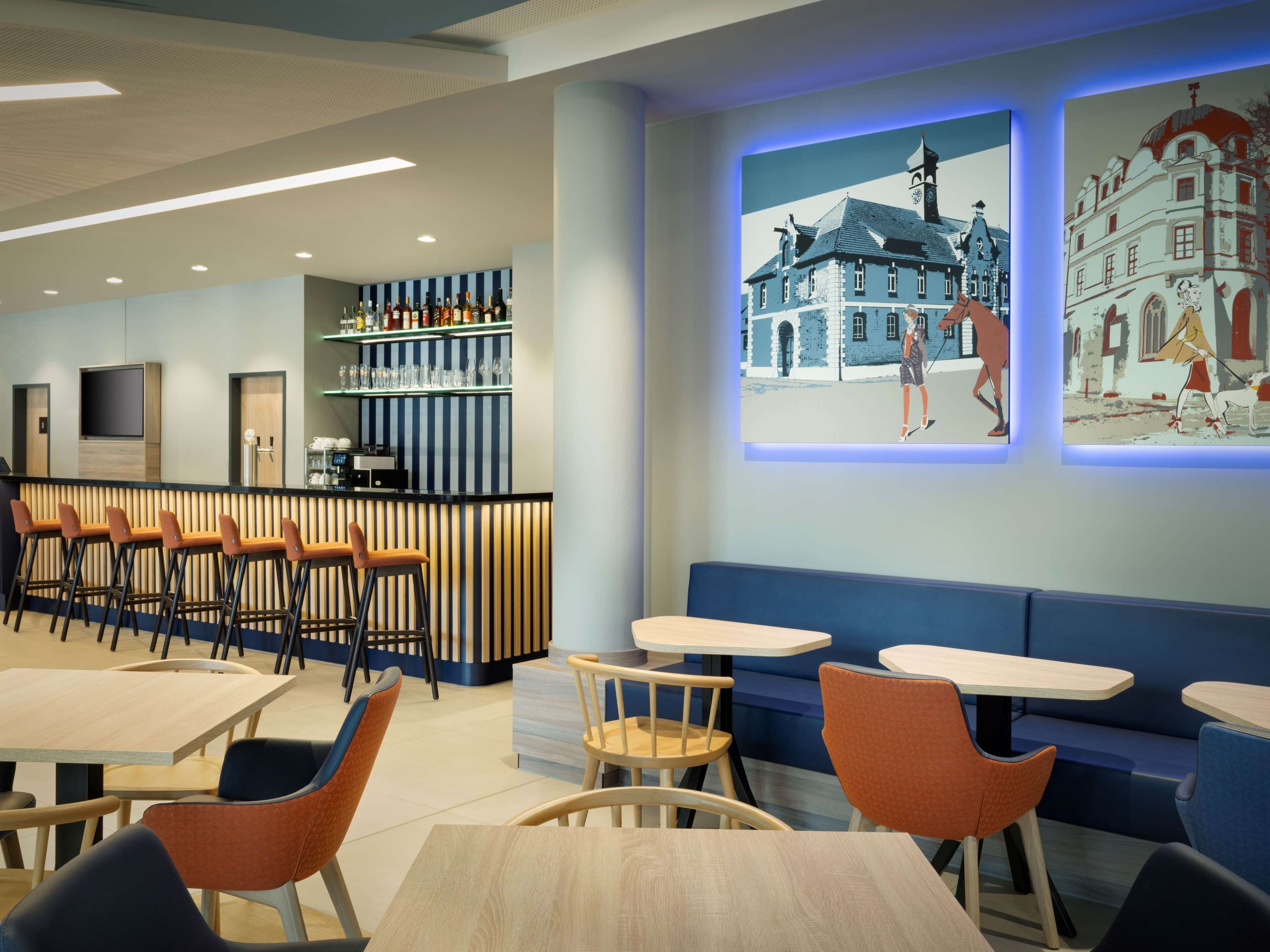 Un restaurant moderne doté d’un bar, de différents espaces pour s’asseoir et d’une projection d’un bâtiment sur le mur.