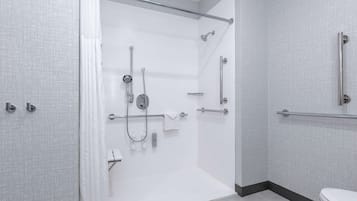 A modern bathroom with a walk-in shower, grab bars, and a toilet.