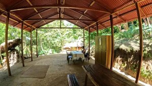 An open-air pavilion with a thatched roof, a table, benches, and a view of a lush forest. - Private waterfall and indigenous house! (Minca)