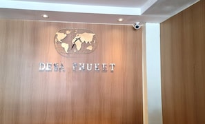 Pared de madera con un mapa del mundo y el texto 'DESSA PHUKET', indicando una ubicación o nombre.