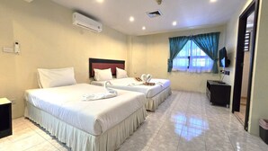 A hotel room with two beds, a TV, and an air conditioning unit. - Desa Phuket (Phuket)