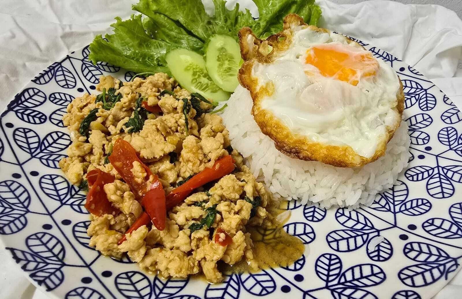 A plate with scrambled eggs, rice, and vegetables.