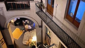 Ein mehrgeschossiges Interieur mit einer Treppe, einem Balkon mit Geländer und einem Fenster mit Aussicht.