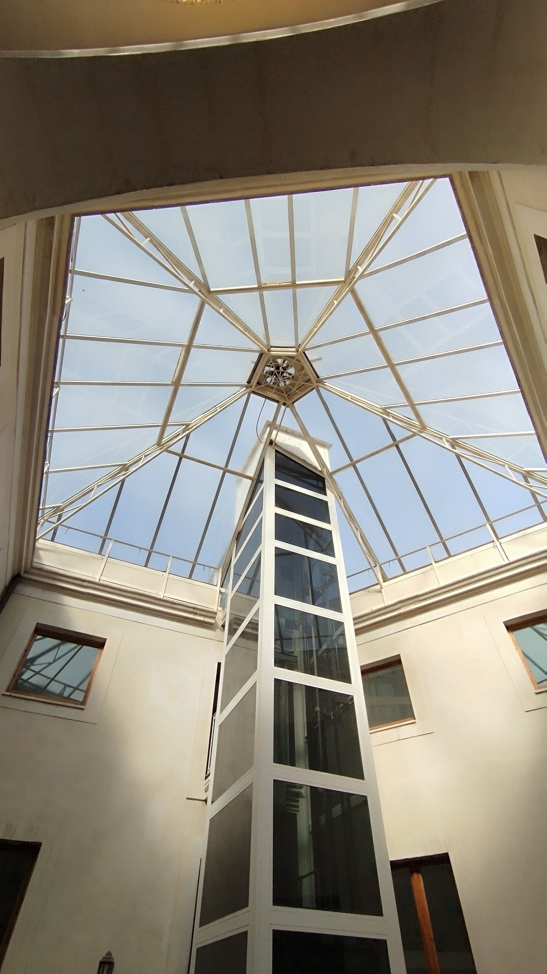 A high-ceilinged room with a skylight and a central clock.