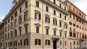 A large, multi-story building with a symmetrical facade, evenly spaced windows, and a central entrance. - Adelaide Suite Dreams (Rome)