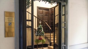A staircase with a Christmas tree and a plaque on the wall. - Adelaide Suite Dreams (Rome)