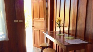 A wooden interior with a table and stools, a door, and a small plant on the table. - TREE HOUSE PLAYA SAMARA (Playa Samara Guanacaste Province)