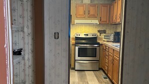 Une cuisine avec des meubles en bois, une cuisinière en acier inoxydable et un four à micro-ondes.