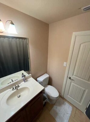 Features a compact bathroom with a sink, mirror, and toilet.