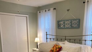 A neatly arranged bedroom with a bed, bedside table, lamp, and a chair. - Rustic and private farmhouse close to Lackawanna State Park, near Elk Mtn Ski  (Dalton)