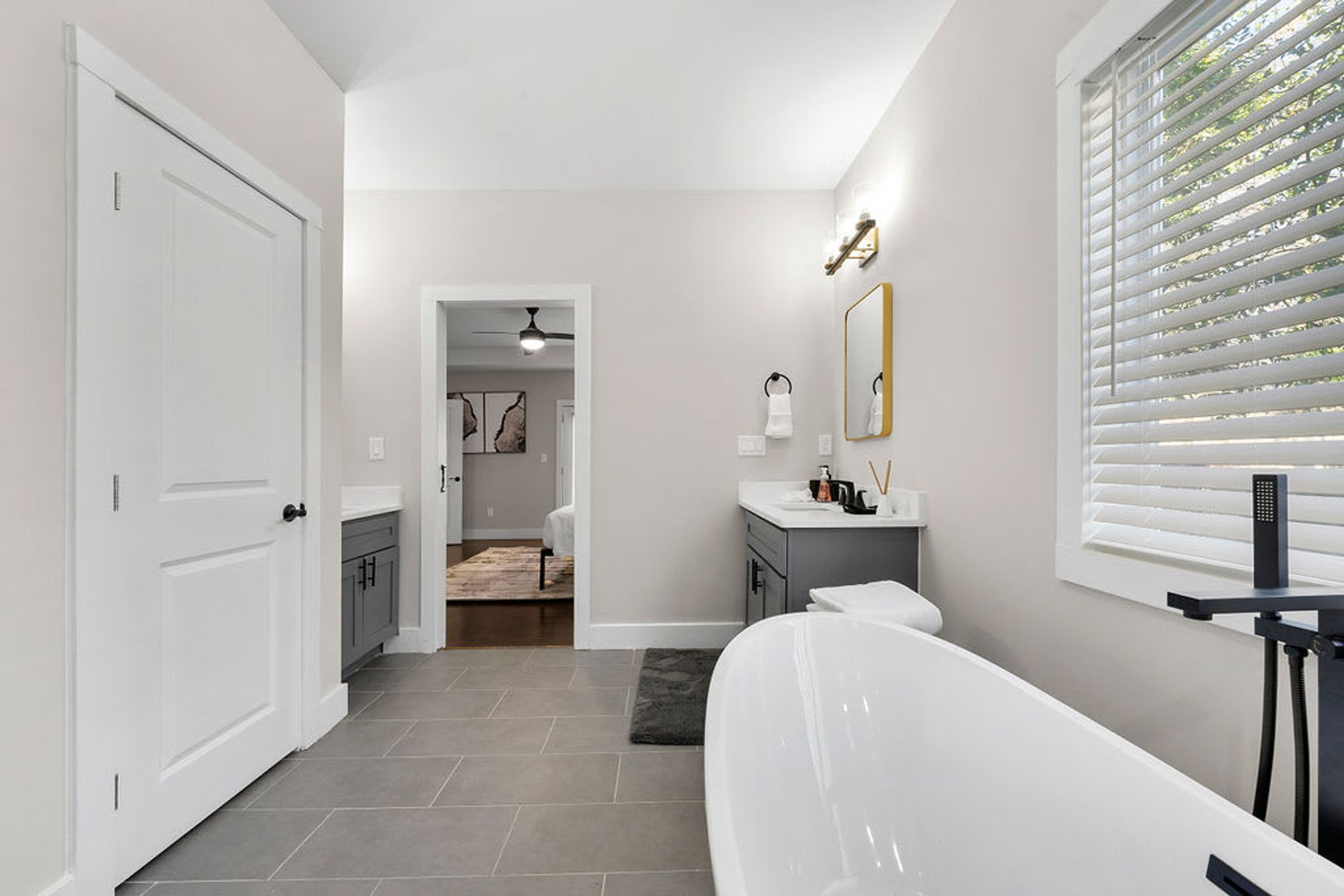 A modern bathroom with a bathtub, a vanity, and a shower area.