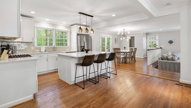 A spacious kitchen with a central island, wooden flooring, and modern lighting fixtures. - Beautiful and Quiet Newly Renovated 4 Bedroom Retreat (Atlanta)