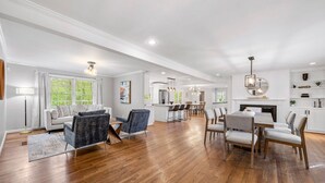 A spacious living room with hardwood flooring, a dining area with a table and chairs, and a kitchen in the background. - Beautiful and Quiet Newly Renovated 4 Bedroom Retreat (Atlanta)