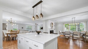 A spacious kitchen with a large island, wooden flooring, and modern pendant lighting. - Beautiful and Quiet Newly Renovated 4 Bedroom Retreat (Atlanta)