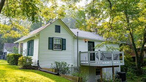 A single-story house with a front porch and a small deck. - Private 1BR Cottage In Downtown Historic Norcross (Norcross)