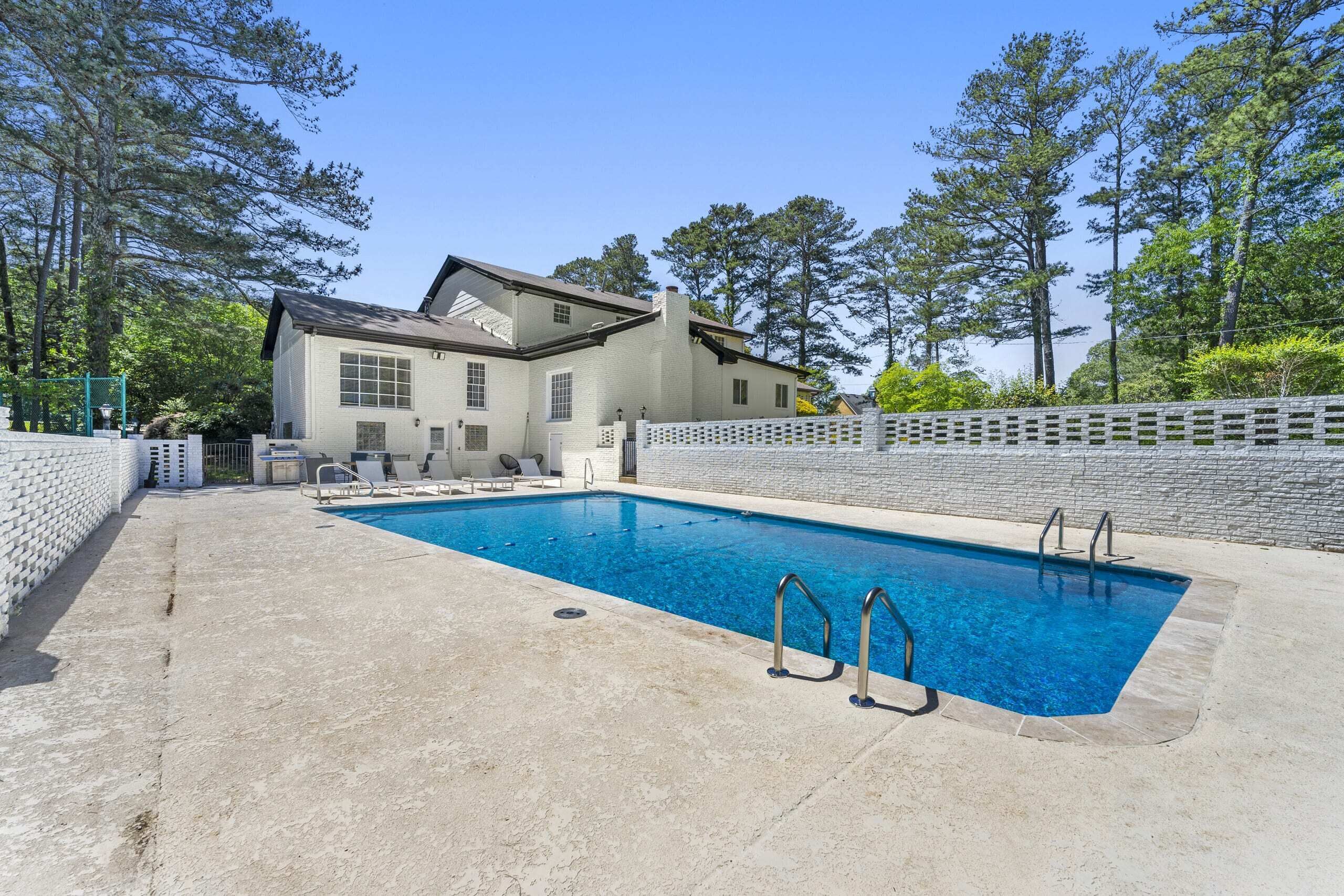 A swimming pool with a house in the background.