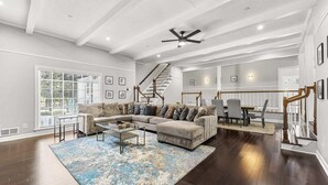 A spacious living room with a large sectional sofa, a coffee table, and a patterned rug. - Mansion With Private Pool Bsktball Tennis Courts (Fayetteville)