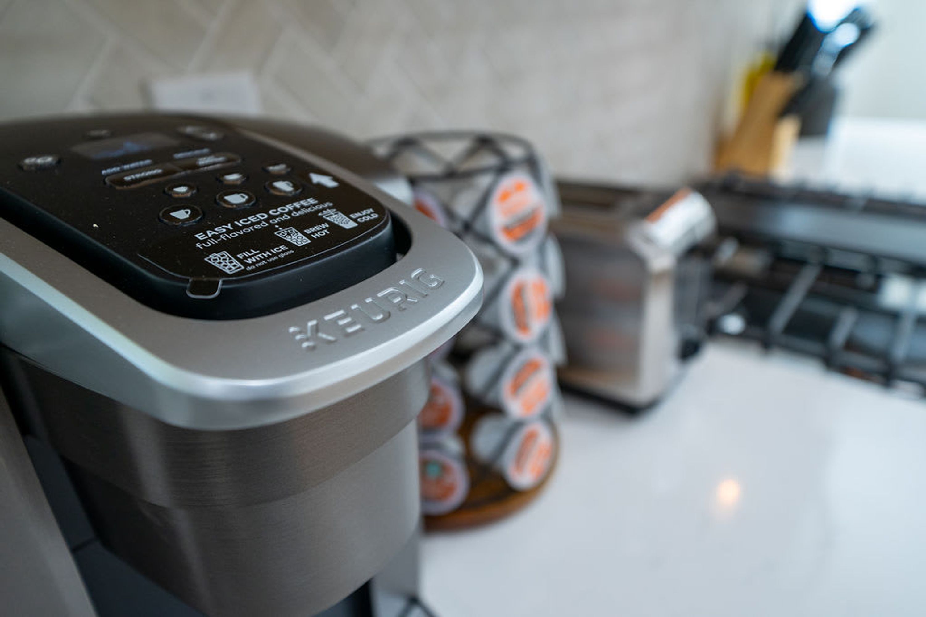 Una cafetera Keurig con un panel de control y un dispensador de cápsulas de café al fondo.