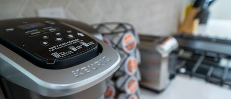 Una cafetera Keurig con un panel de control y un dispensador de cápsulas de café al fondo.