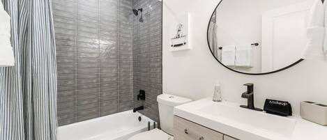 Un baño moderno con bañera, inodoro y lavamanos.