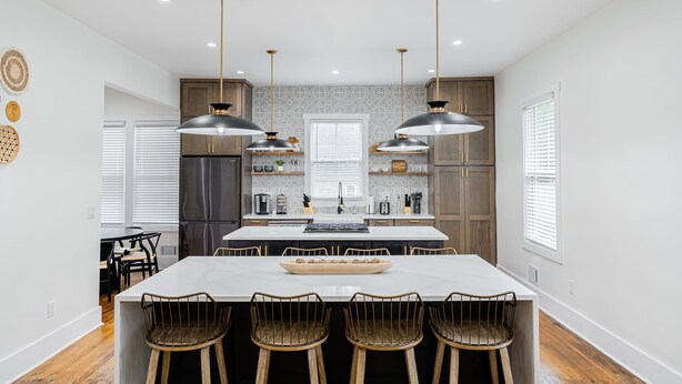 A modern kitchen with a central island, pendant lighting, and wooden cabinetry. - Beautiful Home Located In Historic Norcross (Norcross)