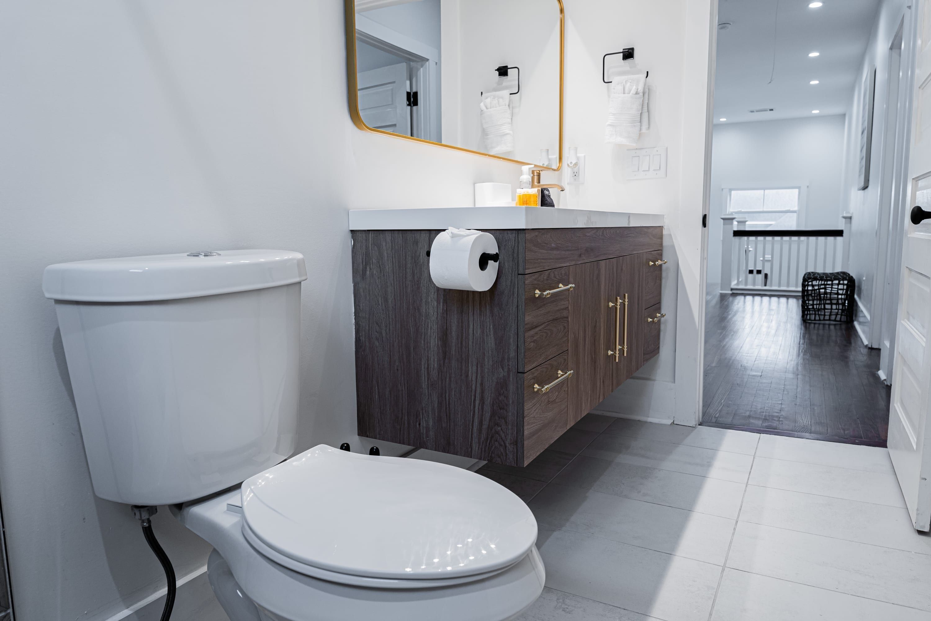 Une salle de bain moderne équipée de toilettes, d  ’un meuble-lavabo et d’un miroir.