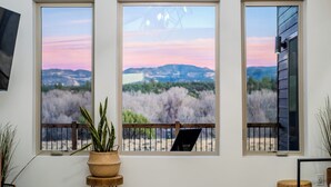 A room with three large windows offering a view of a natural landscape, a wooden bench, and a potted plant. - Brycegate Retreat, Cabin, Star Dome Bedroom, Fire Pit, Hammocks, Views, Pets, EV (Hatch)