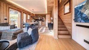 A spacious living area with wooden walls and a large window overlooking a scenic landscape.