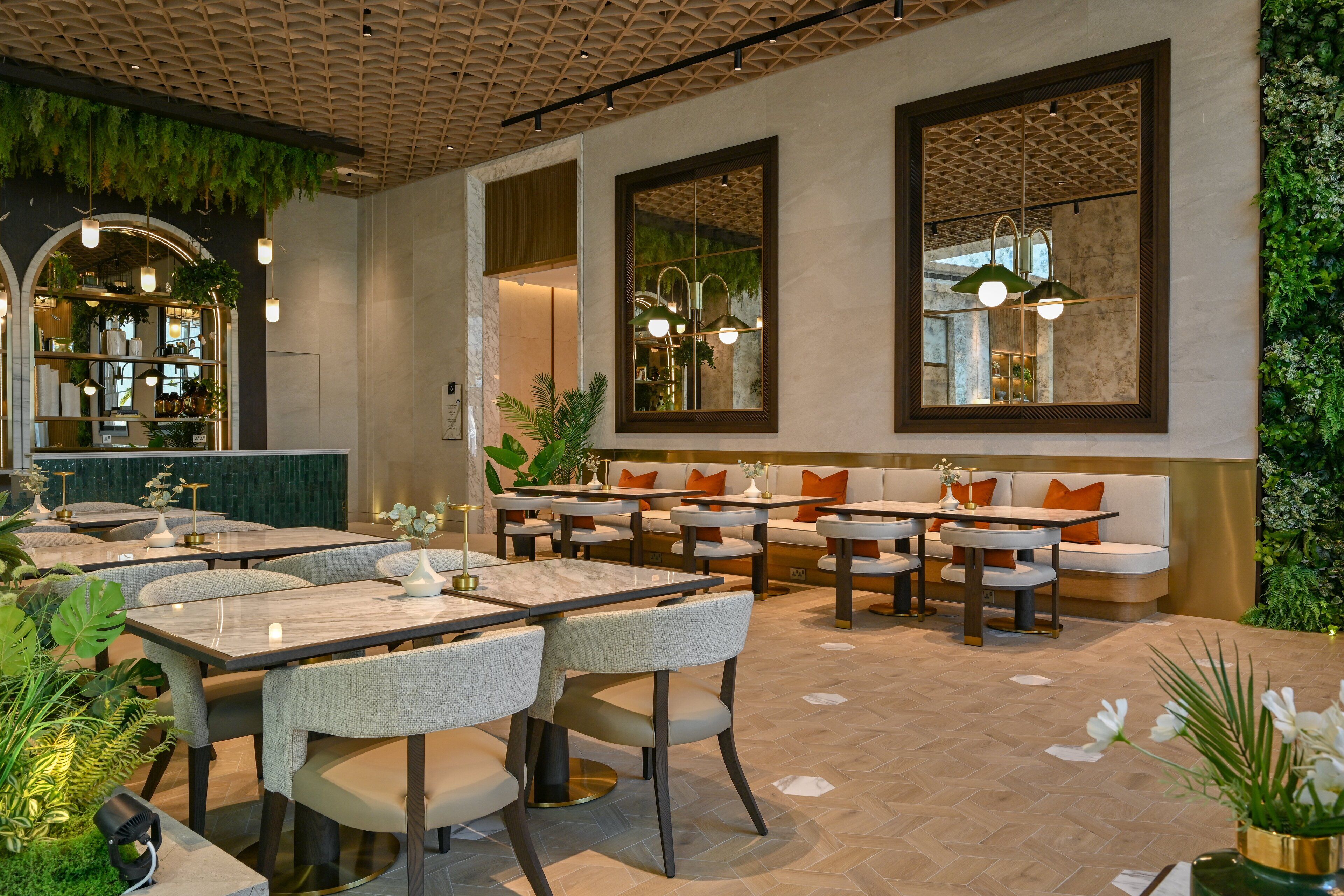 A restaurant with multiple seating areas, including tables and booths, with a herringbone floor pattern.