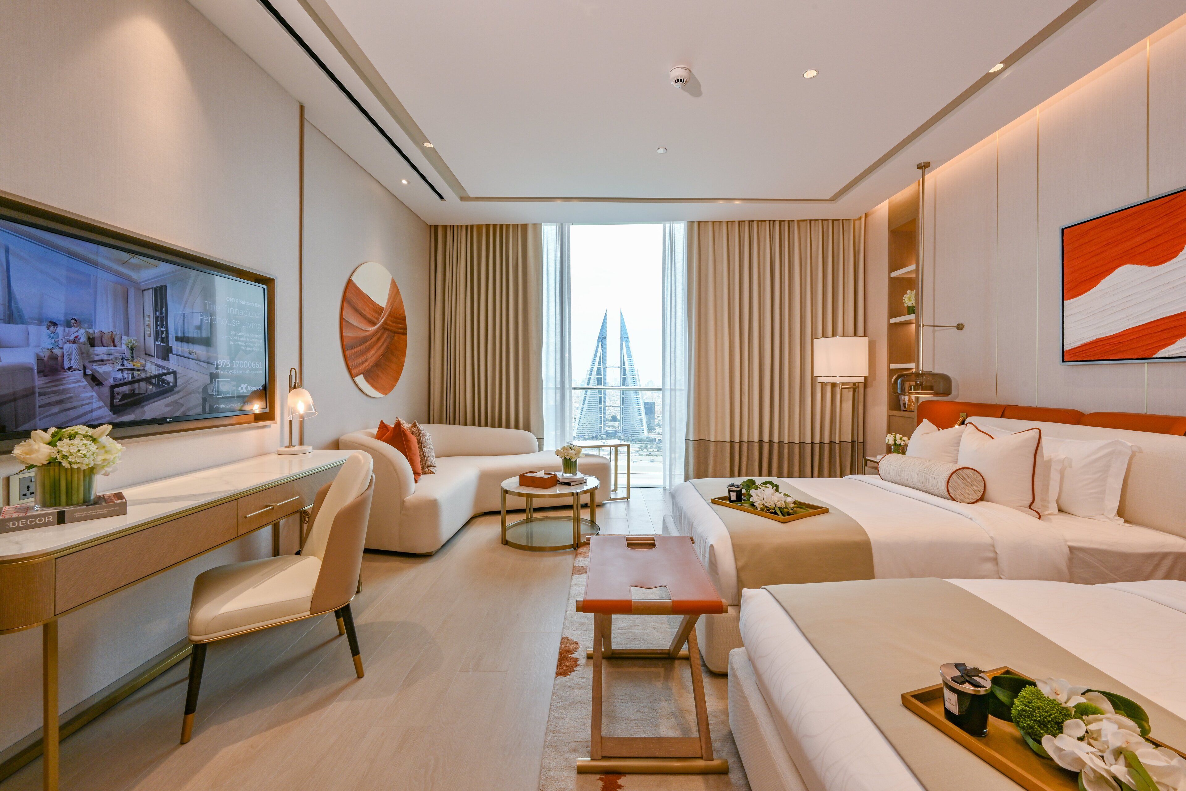 A modern hotel room with a large bed, a desk, a sofa, and a TV.