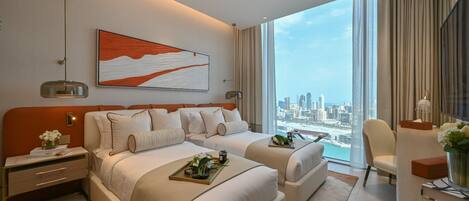 A modern hotel room with two beds, a city view, a large abstract painting, and a desk with a lamp.