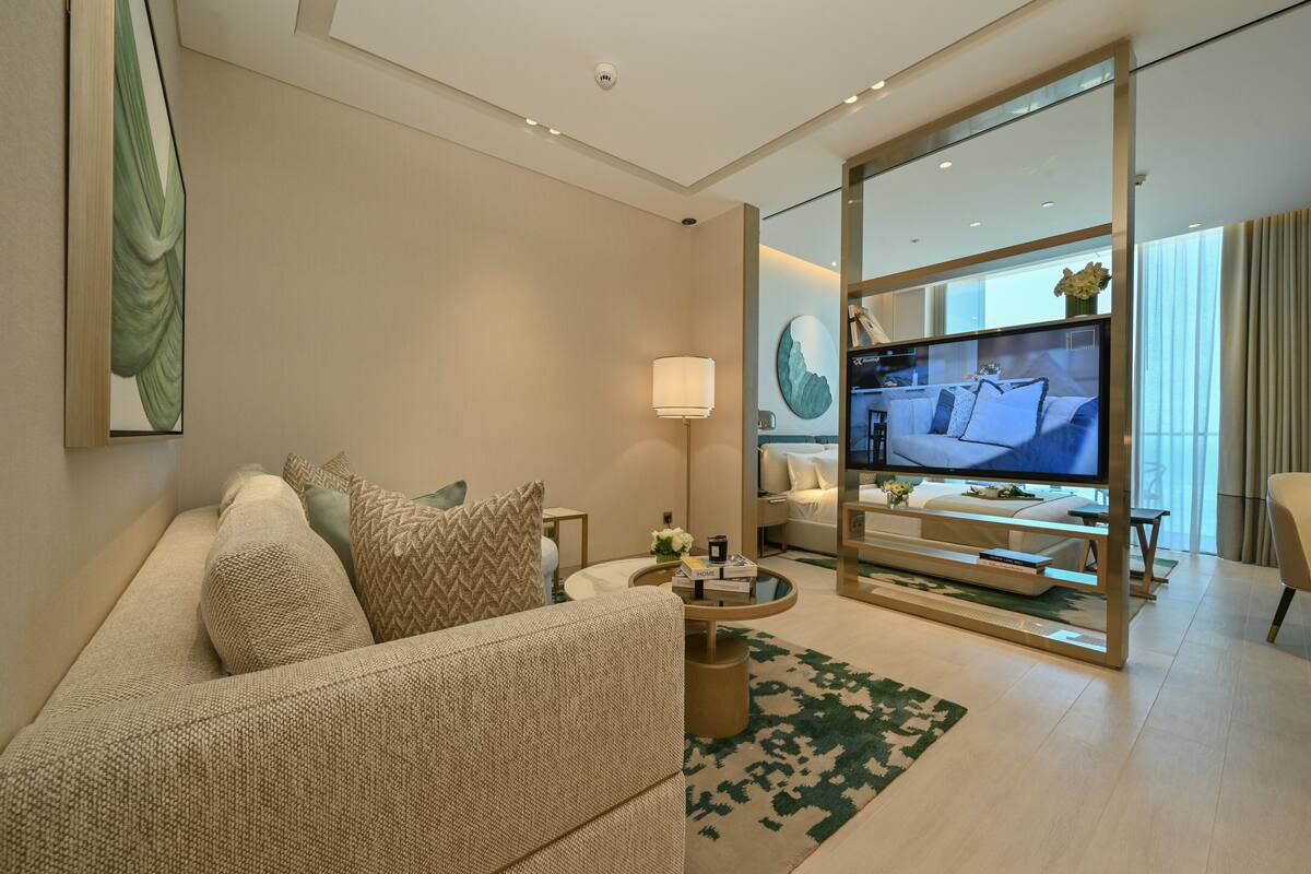 A modern living room with a sofa, coffee table, and a flat-screen TV.
