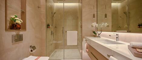 A modern bathroom with a glass-enclosed shower, a large mirror, and a dual sink vanity.