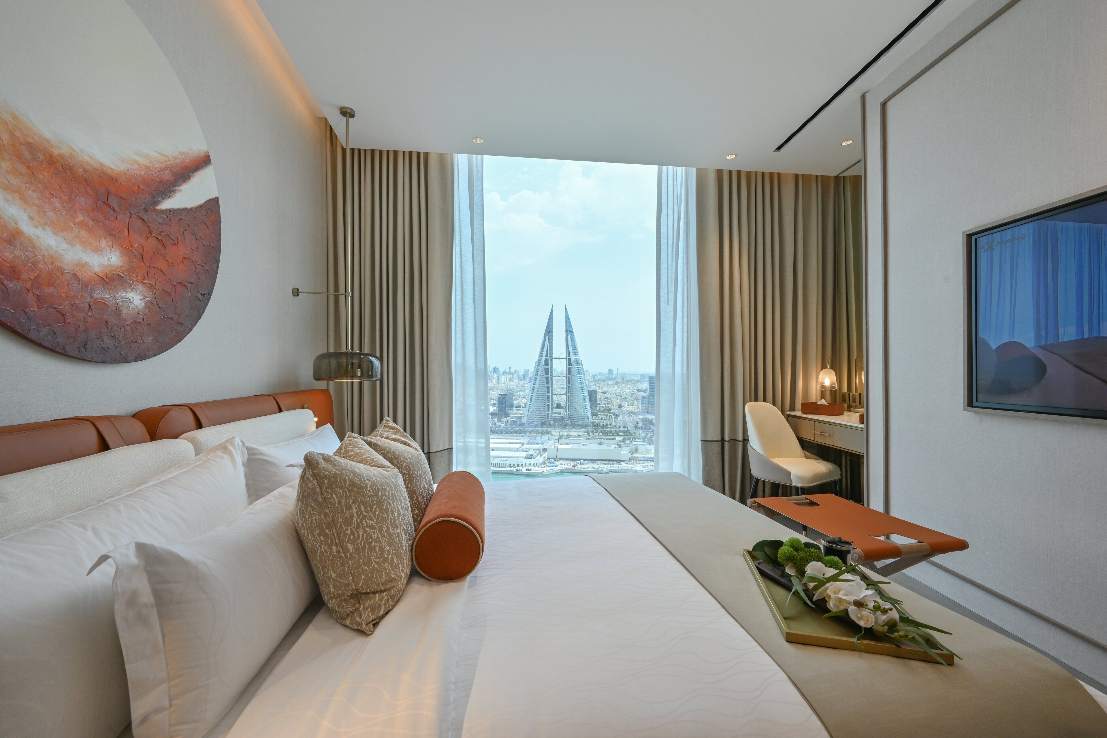 Une chambre d’hôtel moderne avec un grand lit, un bureau et une vue sur le paysage urbain.