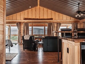 A cozy cabin interior with a wooden ceiling, a dining area, and a view of the mountains. - Private Cabin & Views@GraysonHighlands (Grayson County)