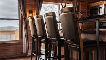 Interior de madeira com área de bar, incluindo banquetas e balcão.