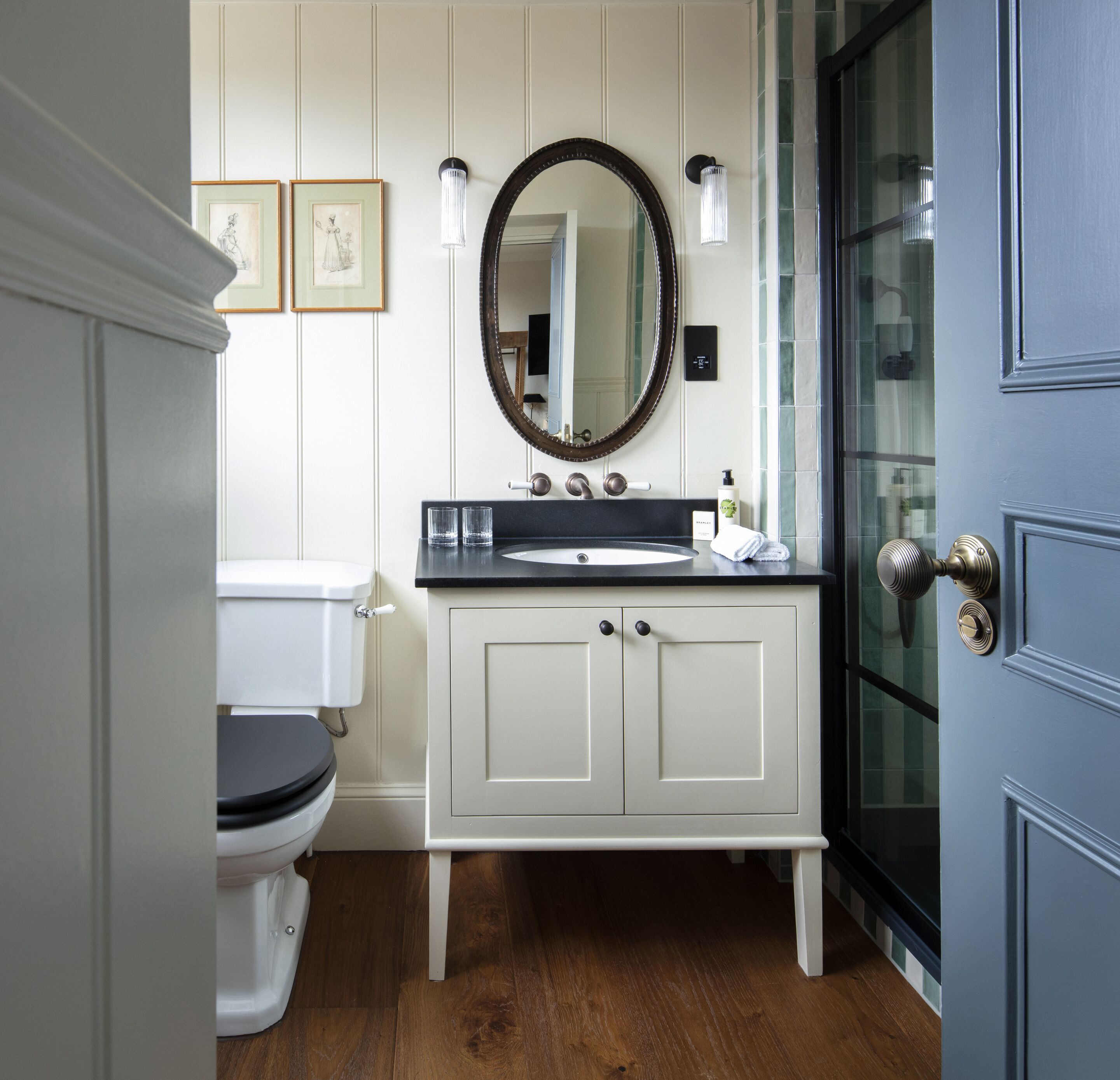 A bathroom with a toilet, sink, and mirror.