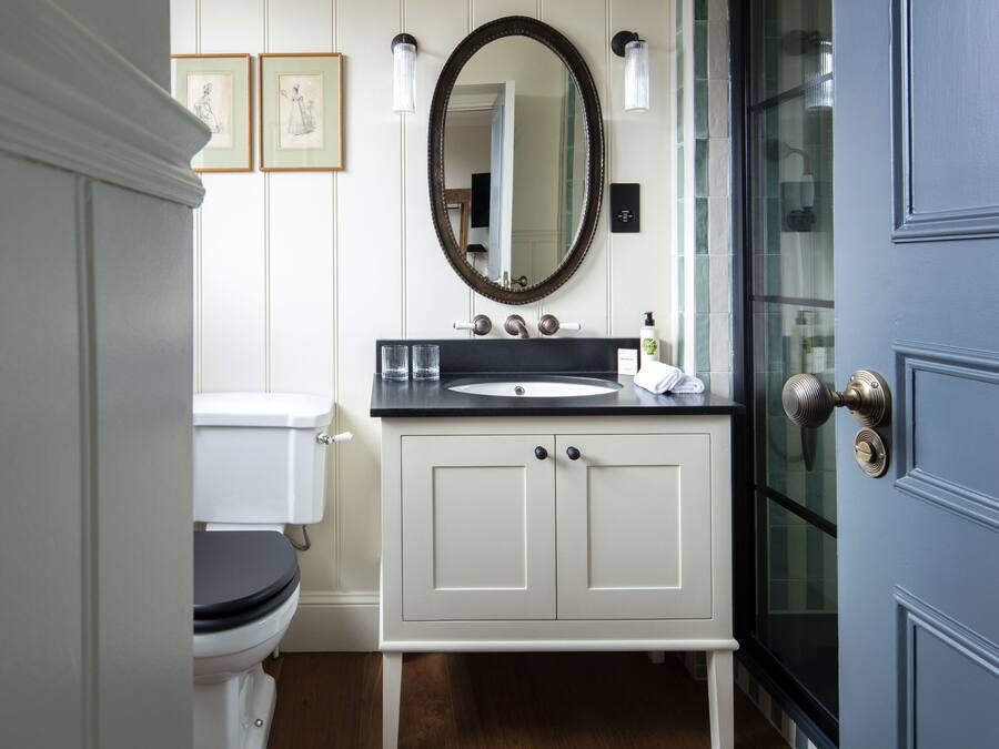 A bathroom with a toilet, sink, and mirror.