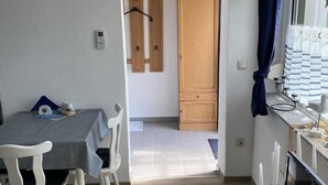 Un coin repas avec une table et des chaises, une porte en bois et une fenêtre avec des rideaux.