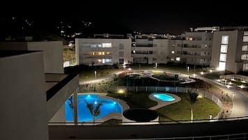 Un bâtiment moderne doté de nombreux balcons et d’un espace piscine.
