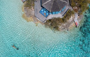 An aerial view of a resort with a wooden deck and a pool area. - A private island in the heart of the Exuma Islands (Exumas Bahamas)