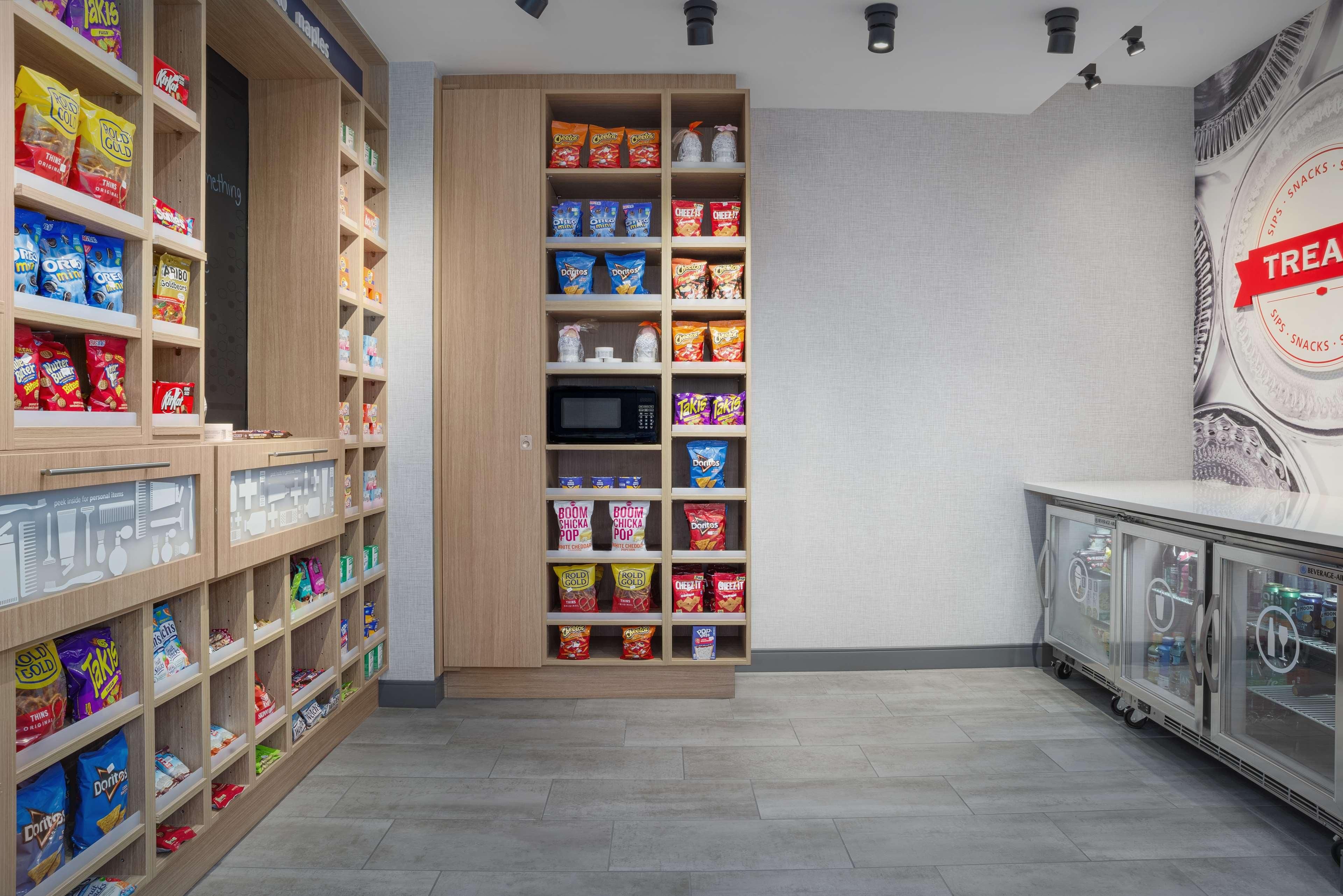 A snack aisle with various packaged snacks and a microwave.