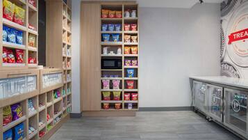 A snack aisle with various packaged snacks and a microwave.