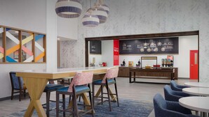 Un comedor moderno con una mesa de madera, sillas azules y lámparas colgantes.