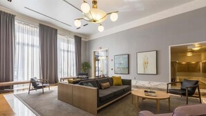 A modern hotel lobby with a sectional sofa, a coffee table, and a seating area with chairs. - Steps from Shops & Nightlife district | nr Ferry + Buses | Hoboken (Hoboken)