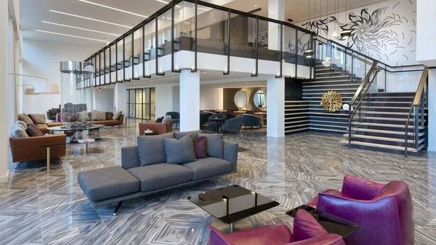 A spacious lobby with a modern staircase, comfortable seating areas, and a polished marble floor. - close to subway 1 BR | near Restaurant Row (Boston)