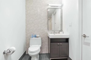 Un baño moderno con inodoro, lavamanos y mueble.